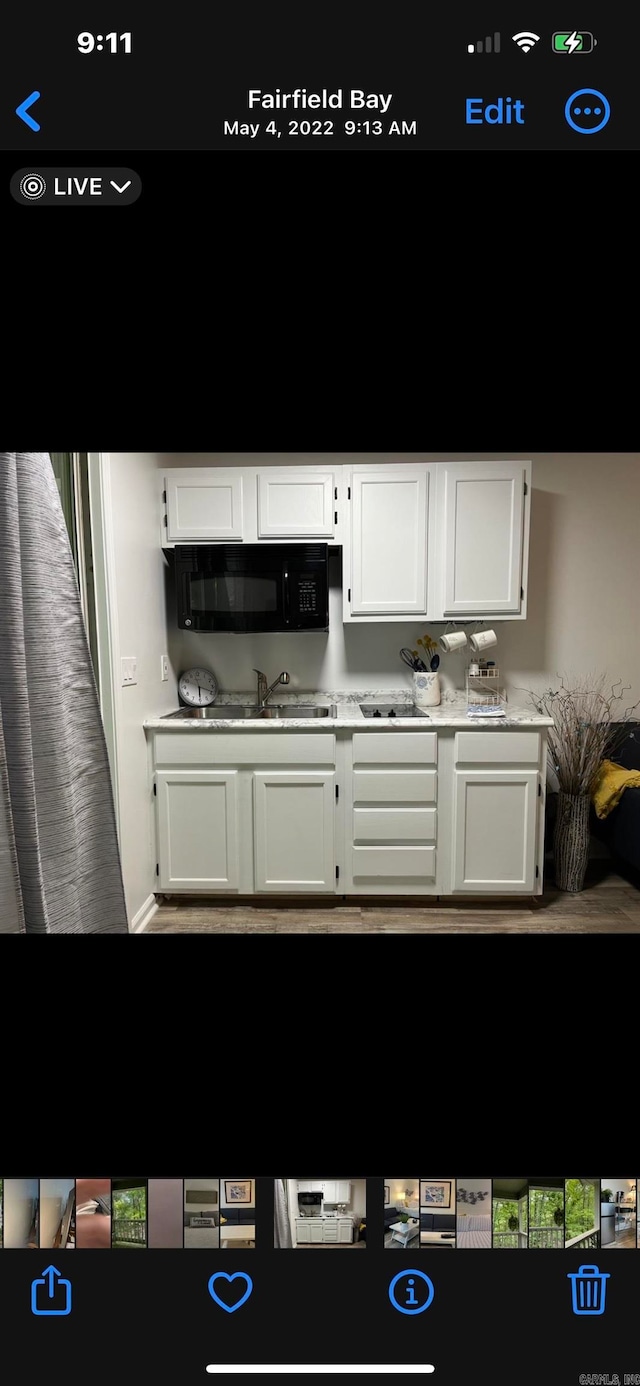 kitchen featuring wood-type flooring and white cabinets