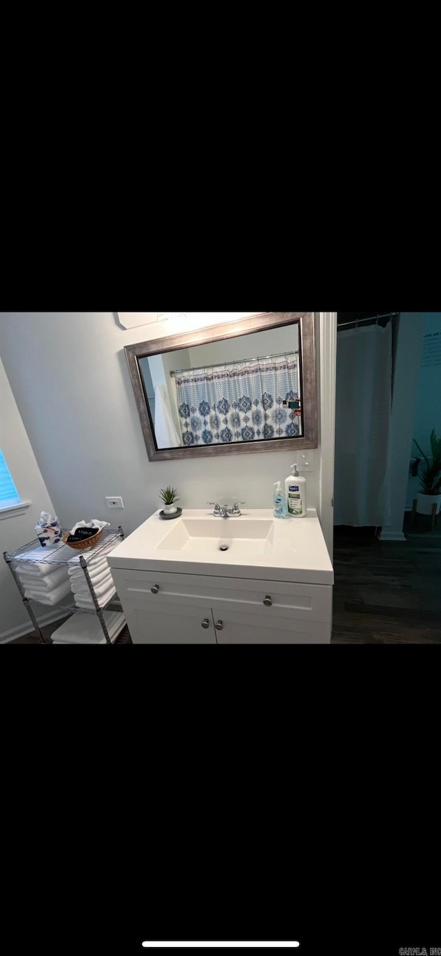 bathroom featuring a skylight, hardwood / wood-style floors, and vanity