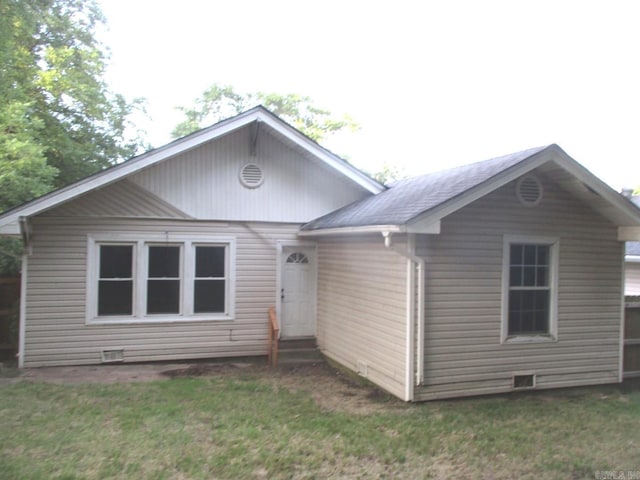 rear view of property with a yard