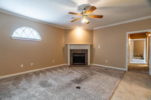 unfurnished living room featuring ceiling fan, ornamental molding, light carpet, and a tiled fireplace