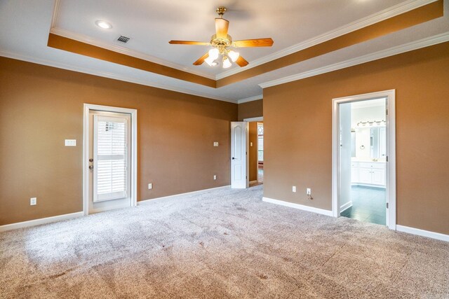 carpeted empty room with ceiling fan, ornamental molding, and a tray ceiling