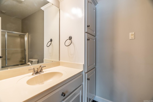 bathroom featuring vanity, toilet, and an enclosed shower