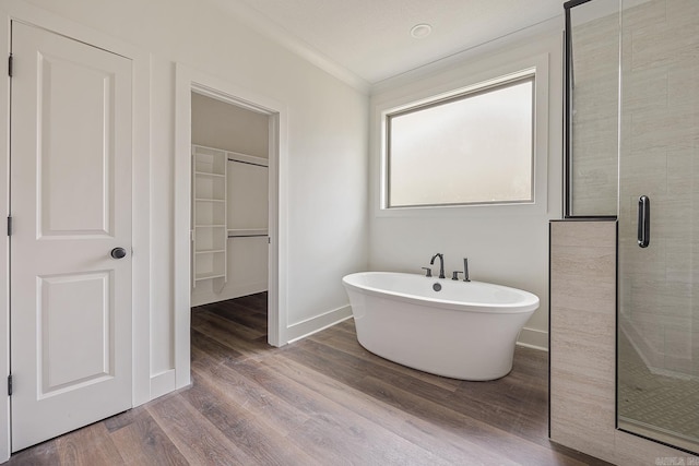 bathroom featuring hardwood / wood-style flooring, separate shower and tub, and crown molding