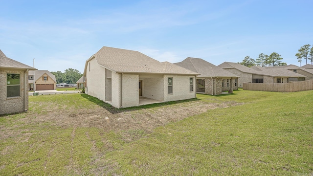 back of house featuring a lawn and a patio area