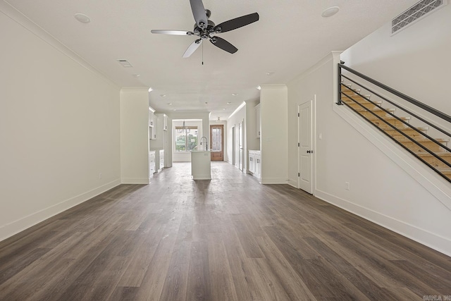 unfurnished living room featuring ceiling fan, dark hardwood / wood-style flooring, and ornamental molding