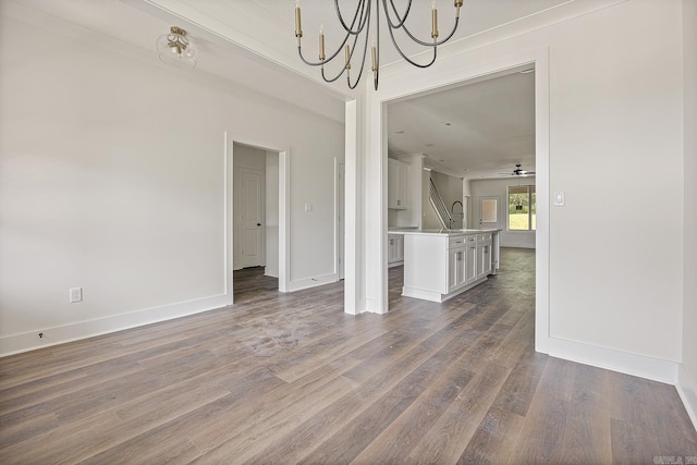 unfurnished dining area with wood-type flooring and ceiling fan with notable chandelier