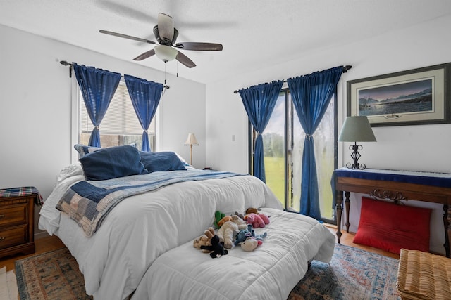 bedroom featuring ceiling fan, hardwood / wood-style floors, and a textured ceiling