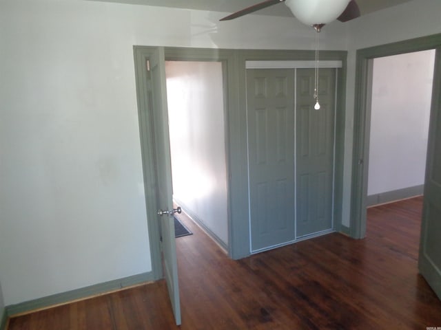 unfurnished bedroom with dark hardwood / wood-style flooring, ceiling fan, and a closet