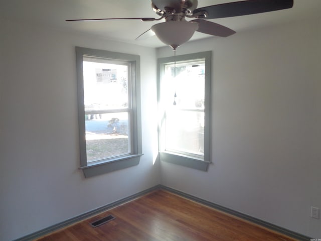 unfurnished room featuring dark hardwood / wood-style floors and ceiling fan