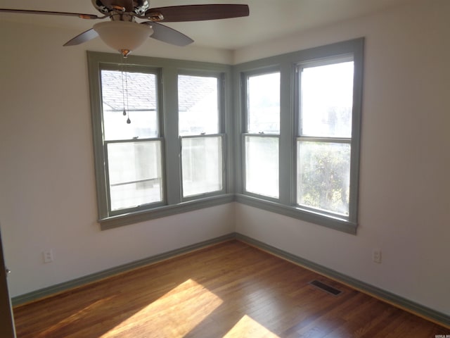 empty room with ceiling fan and wood-type flooring