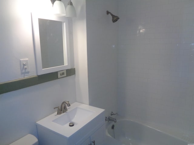 full bathroom with toilet, vanity, and tiled shower / bath