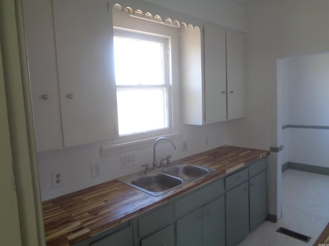 kitchen featuring butcher block counters, sink, and tasteful backsplash