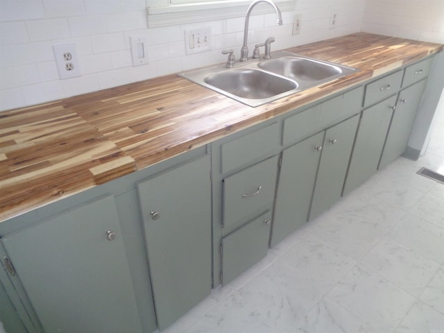 kitchen with wooden counters, sink, and tasteful backsplash