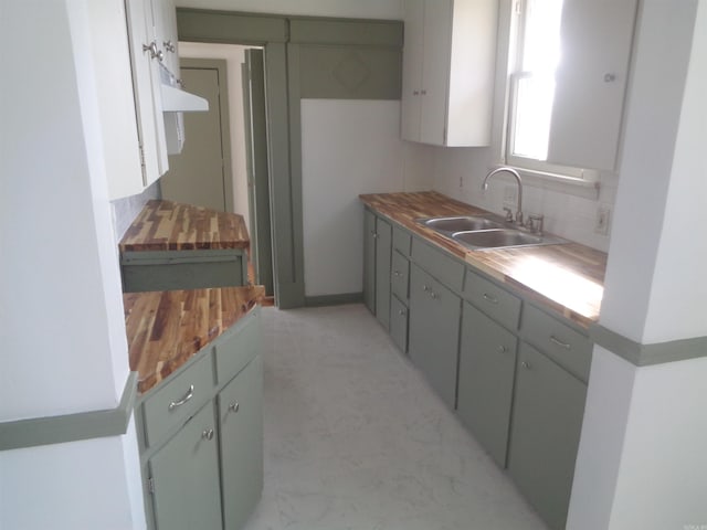 kitchen featuring butcher block countertops, sink, and tasteful backsplash