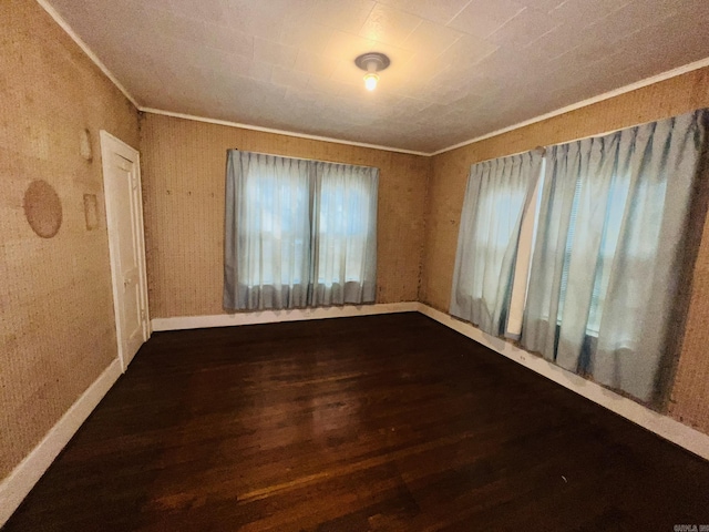 empty room featuring dark hardwood / wood-style flooring and ornamental molding