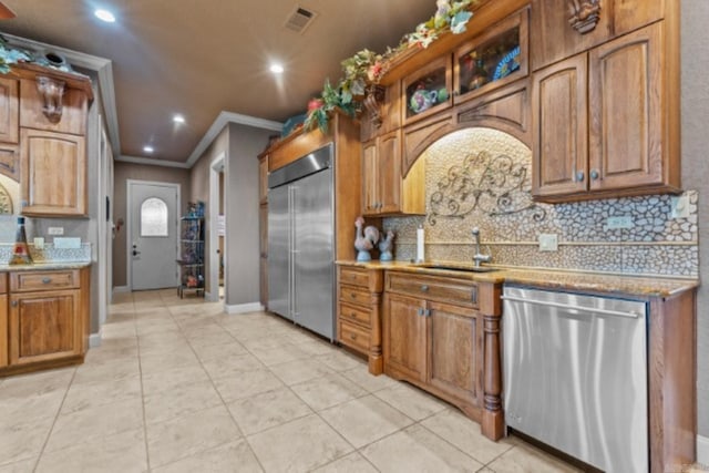 kitchen with decorative backsplash, sink, ornamental molding, and appliances with stainless steel finishes