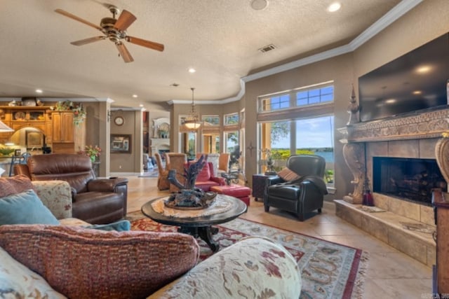 tiled living room featuring a tile fireplace, a textured ceiling, ceiling fan, and crown molding