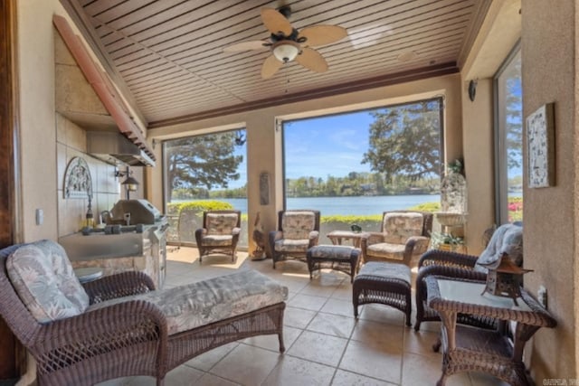 sunroom / solarium featuring ceiling fan and a water view