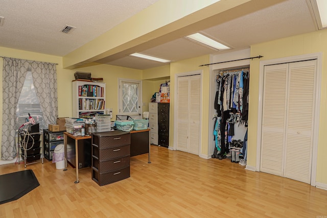 home office featuring light hardwood / wood-style floors and a textured ceiling