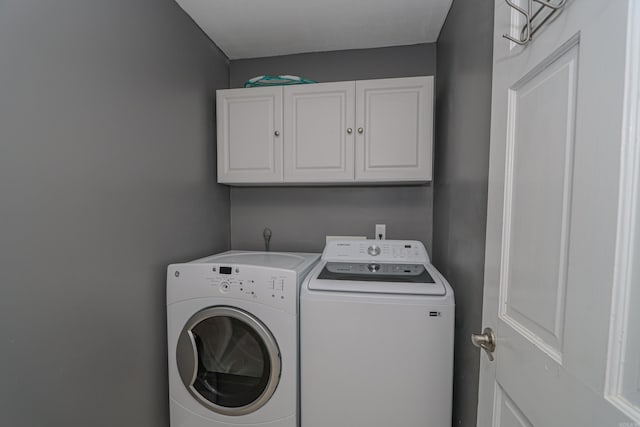 laundry room featuring cabinets and washer and dryer