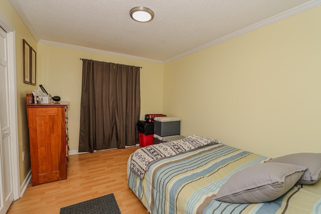 bedroom featuring crown molding, a textured ceiling, and light hardwood / wood-style flooring