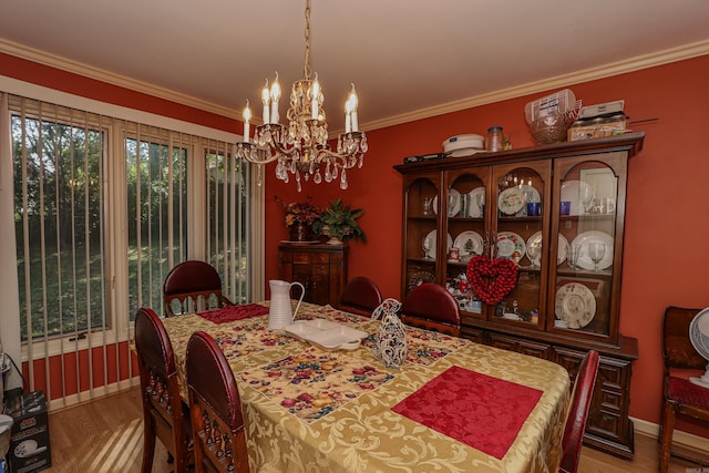 dining room featuring hardwood / wood-style floors, ornamental molding, and a notable chandelier