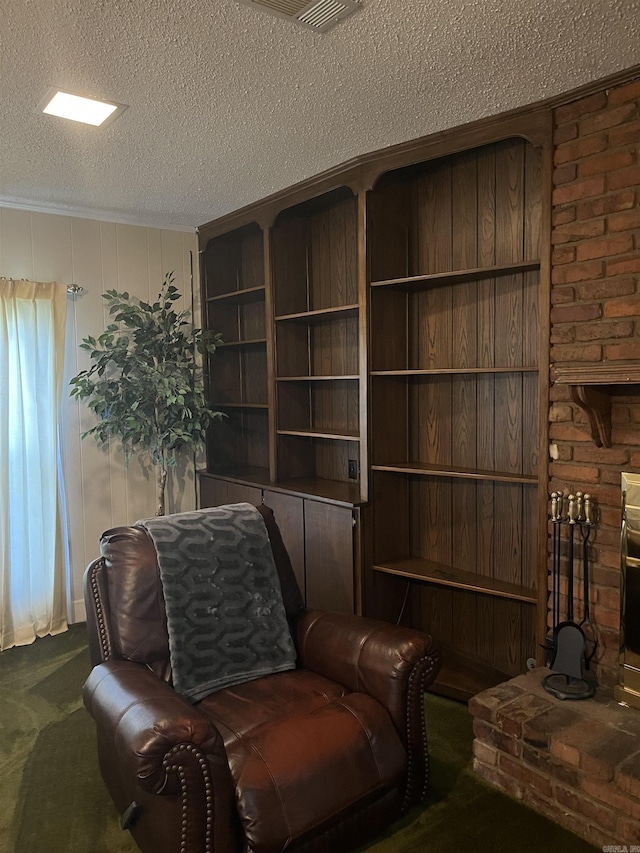 sitting room featuring a textured ceiling and dark carpet