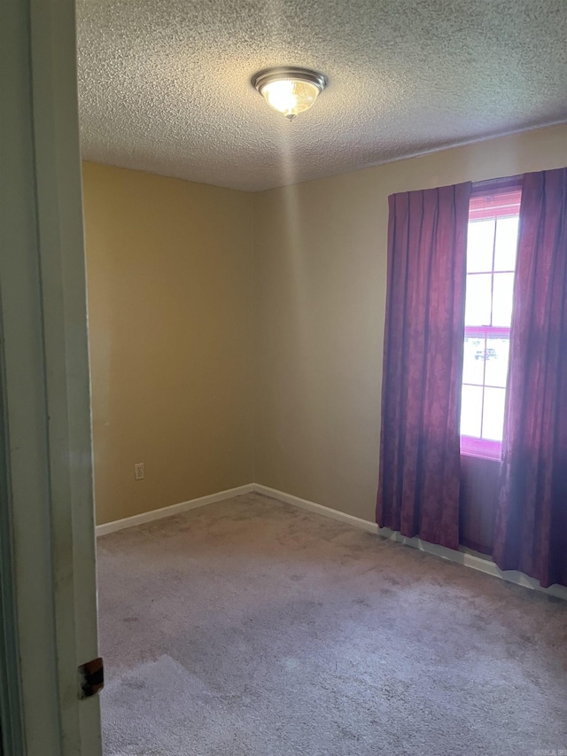 carpeted spare room with a textured ceiling