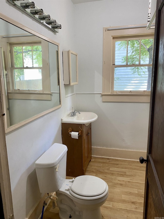 bathroom featuring wood-type flooring, vanity, and toilet