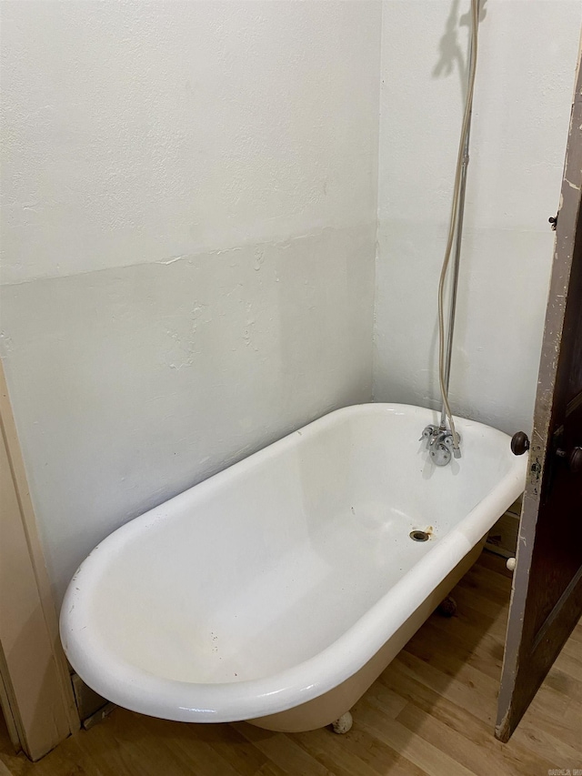 bathroom with a bath and hardwood / wood-style flooring