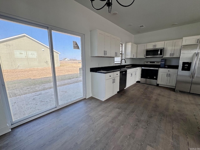 kitchen with plenty of natural light, white cabinetry, dark hardwood / wood-style floors, and stainless steel appliances