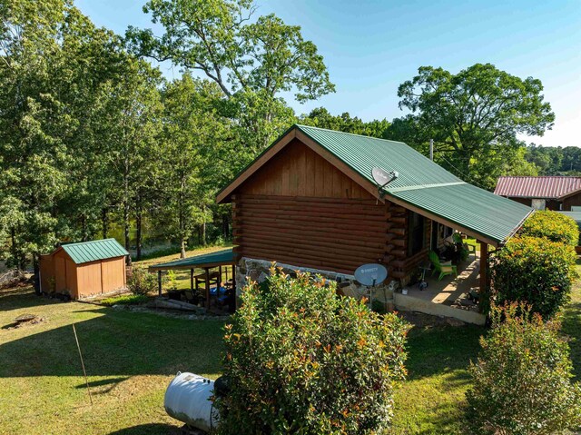 view of side of property with a yard and a storage unit