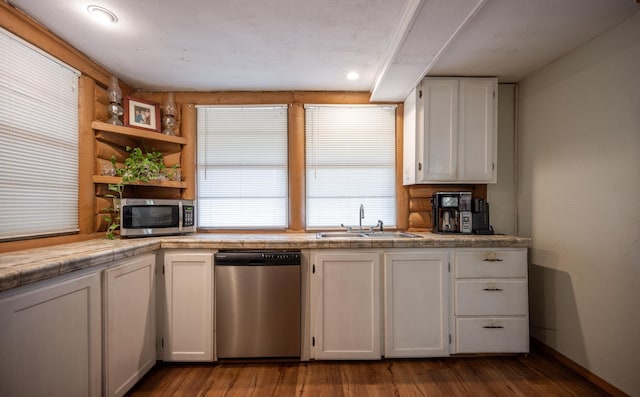 kitchen with stainless steel appliances, sink, white cabinets, and light wood-type flooring