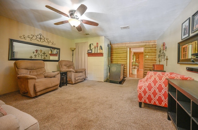 living room with ceiling fan, log walls, and carpet floors