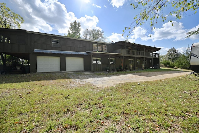 back of property featuring a garage and a yard