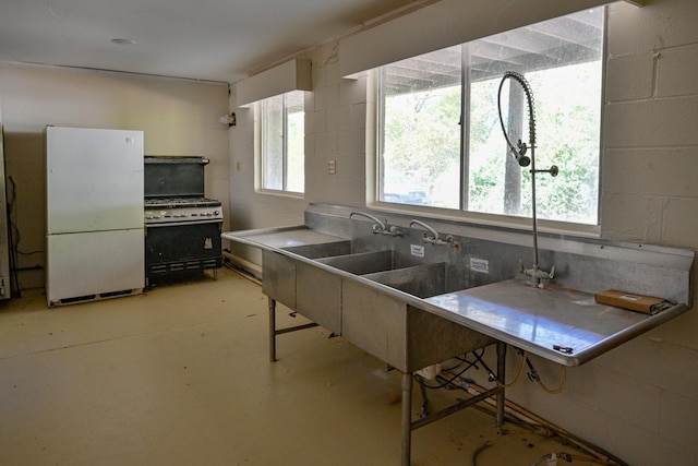 kitchen featuring a kitchen bar, gas stove, and white fridge