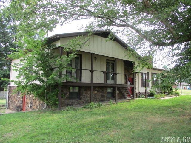 view of front of property featuring stairs, a front lawn, and stone siding