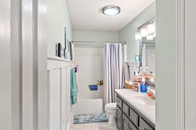 full bathroom featuring vanity, a textured ceiling, shower / bath combination with curtain, and toilet