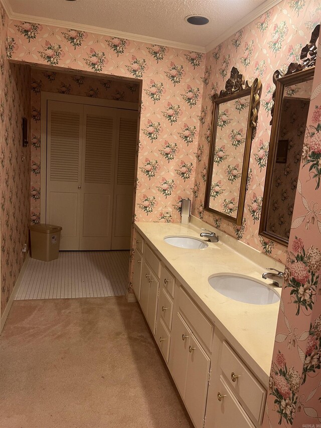 bathroom featuring ornamental molding, dual vanity, and a textured ceiling