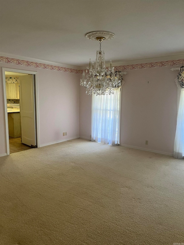 spare room with an inviting chandelier and carpet flooring