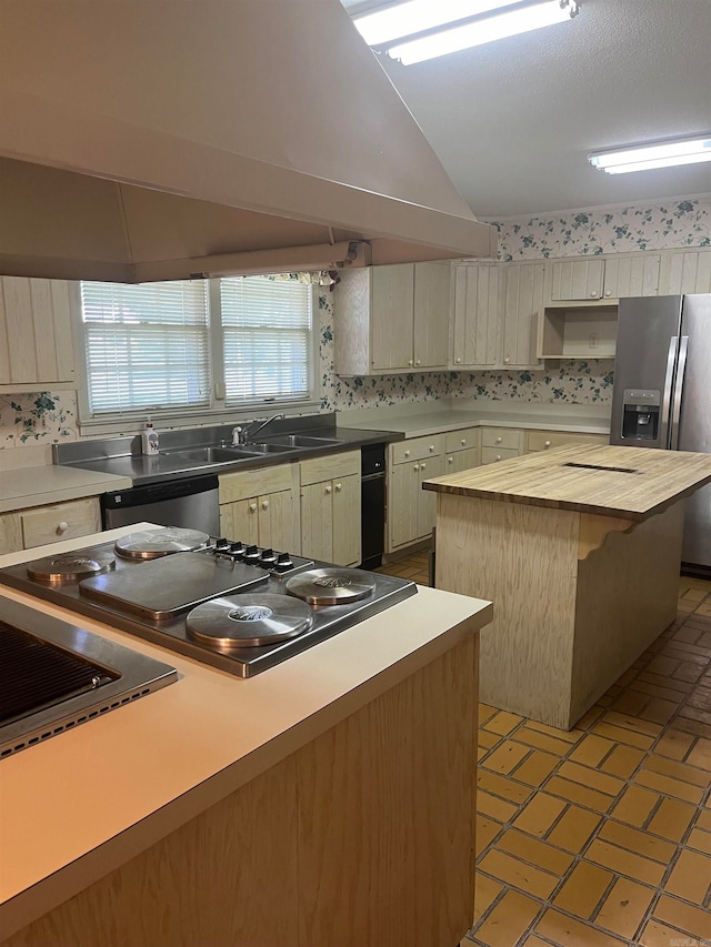 kitchen with lofted ceiling, light tile patterned floors, backsplash, a center island, and stainless steel appliances