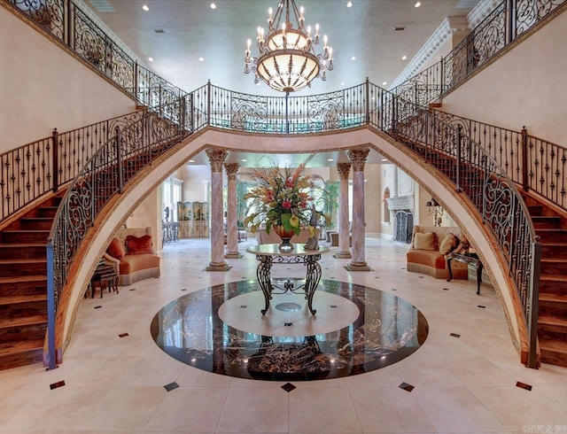 interior space with a notable chandelier, decorative columns, and a towering ceiling