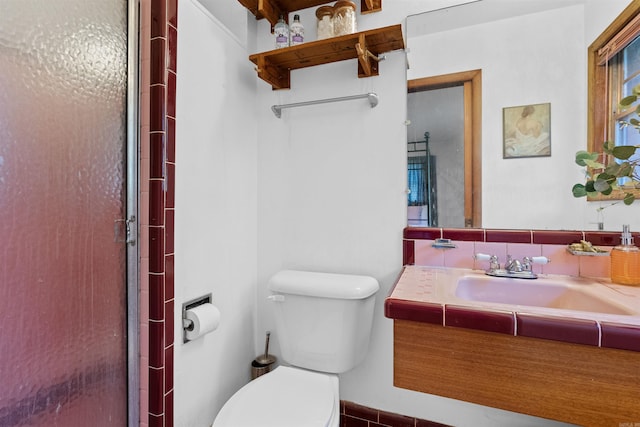 bathroom featuring a shower with shower door, toilet, and vanity