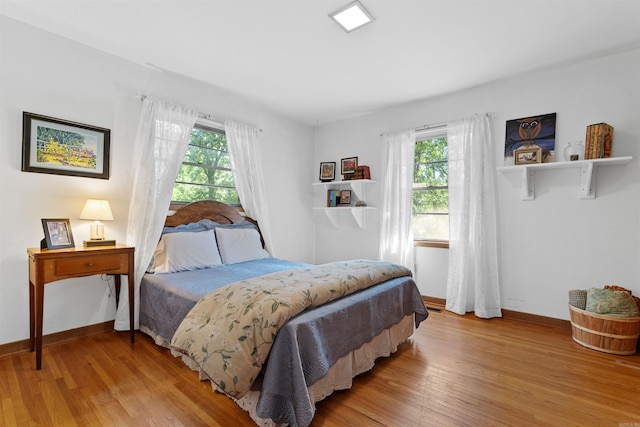 bedroom with light hardwood / wood-style floors and multiple windows