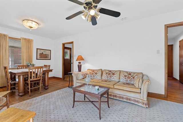 living room featuring wood-type flooring and ceiling fan