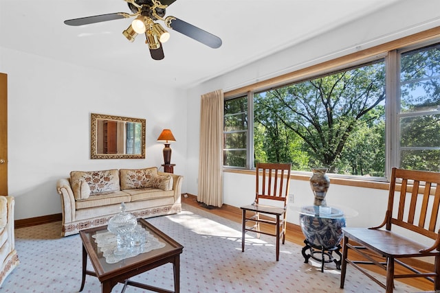 living room featuring a healthy amount of sunlight, ceiling fan, and light wood-type flooring