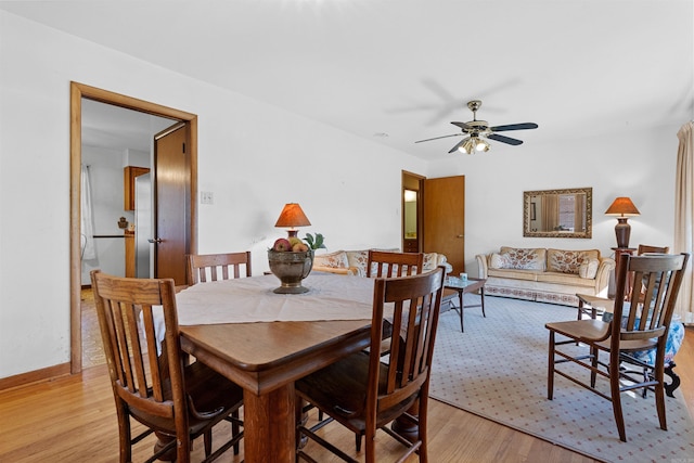 dining area with light wood-type flooring and ceiling fan