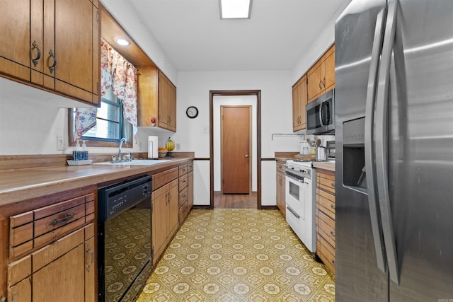 kitchen with sink, light tile patterned floors, and stainless steel appliances