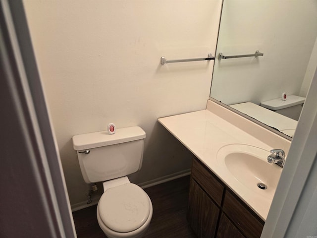 bathroom with hardwood / wood-style flooring, toilet, and vanity