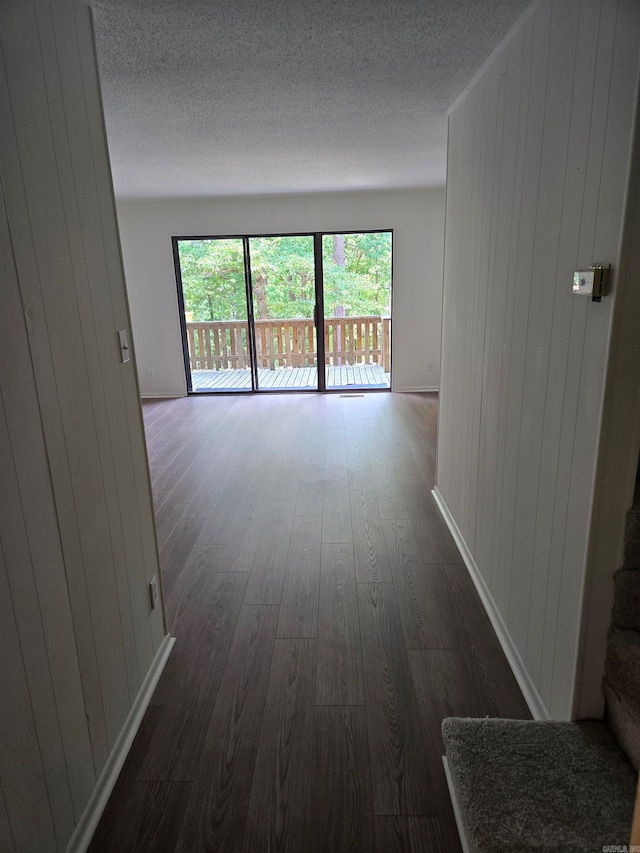 unfurnished room featuring a textured ceiling and dark wood-type flooring